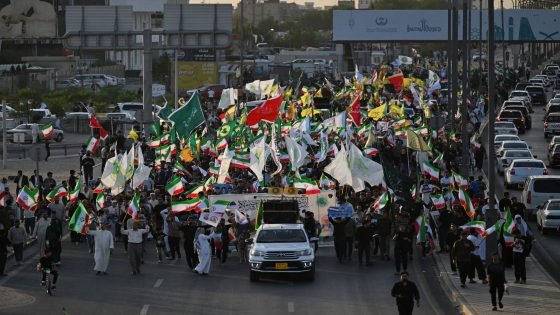 Iraqis march waving Iranian national flags during celebrations to mark the ceasefire between Israel and Iran in the southern city of Basra on June 24, 2025. Iranian President Masoud Pezeshkian announced the "end of the 12-day war" imposed by Israel, in a message to the nation carried by the official IRNA news agency on June 24. (Photo by Hussein FALEH / AFP)